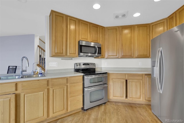 3109 S Jebel Way, Aurora, CO 80013 - kitchen with appliances with stainless steel finishes, a sink, light countertops, light wood finished floors, and light brown cabinetry