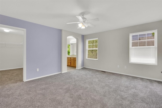 3109 S Jebel Way, Aurora, CO 80013 - unfurnished bedroom with arched walkways, a walk in closet, light colored carpet, a closet, and baseboards
