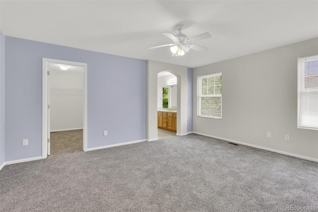 3109 S Jebel Way, Aurora, CO 80013 - unfurnished bedroom with arched walkways, light colored carpet, a spacious closet, and baseboards
