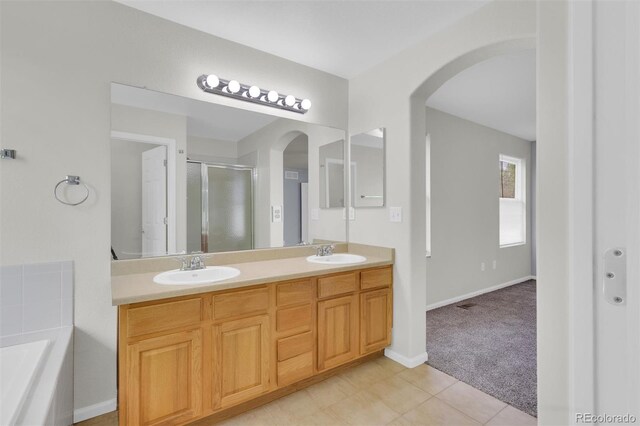 3109 S Jebel Way, Aurora, CO 80013 - bathroom featuring a stall shower, double vanity, a bath, baseboards, and tile patterned floors