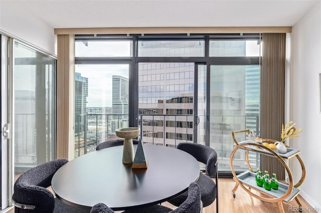 dining area with hardwood / wood-style floors and expansive windows