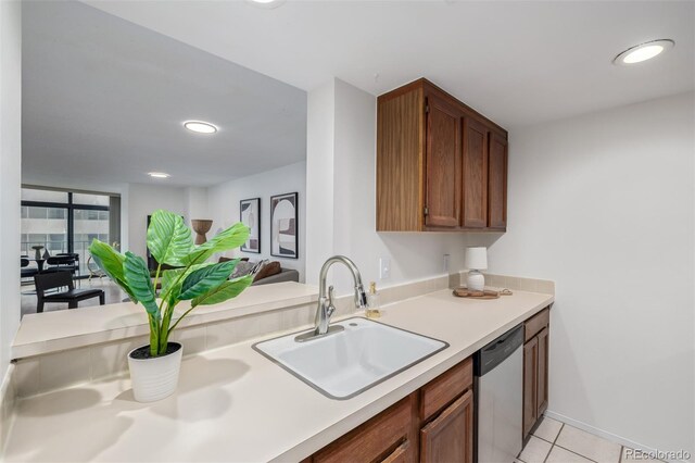 kitchen featuring stainless steel dishwasher, sink, and light tile patterned floors