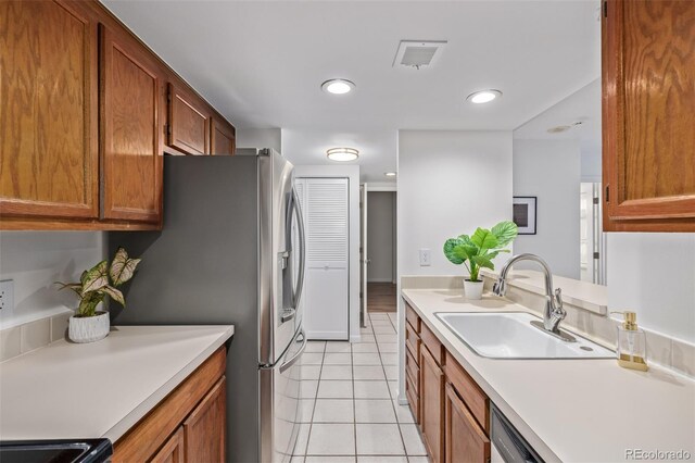 kitchen with dishwashing machine, black electric range oven, sink, stainless steel fridge, and light tile patterned flooring