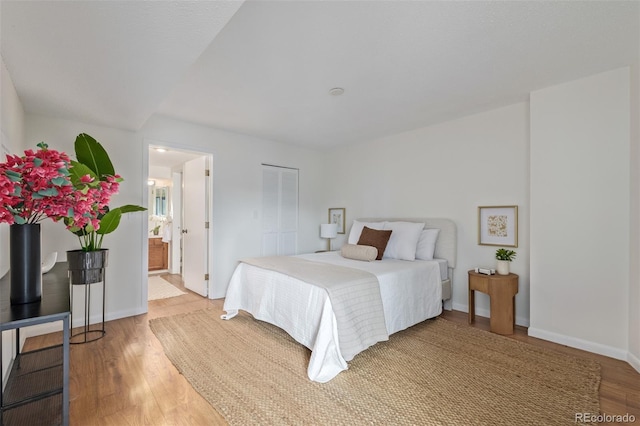 bedroom featuring hardwood / wood-style flooring and ensuite bath