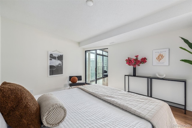 bedroom with hardwood / wood-style flooring and a textured ceiling