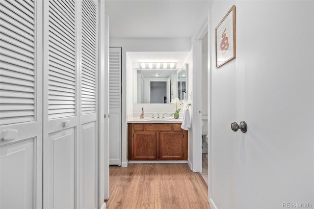 corridor featuring sink and light hardwood / wood-style flooring