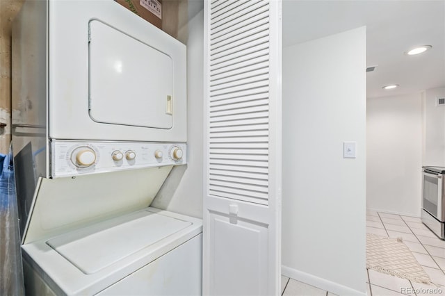 washroom featuring stacked washer / dryer and light tile patterned flooring