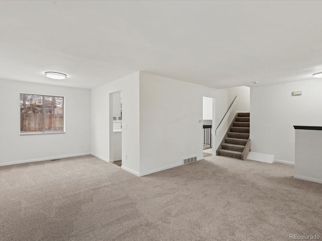 interior space featuring carpet, stairs, visible vents, and baseboards