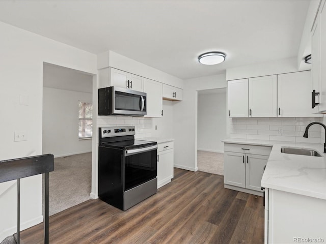 kitchen featuring tasteful backsplash, appliances with stainless steel finishes, white cabinets, and a sink