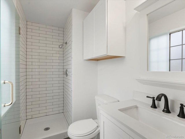 full bathroom featuring a stall shower, vanity, and toilet