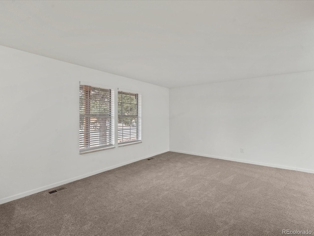 carpeted empty room with visible vents and baseboards