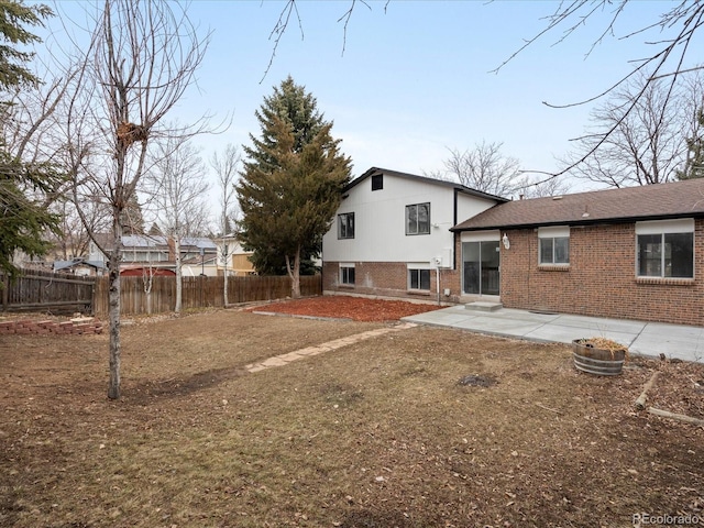 back of property featuring a patio, brick siding, and fence