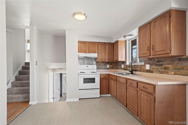 kitchen featuring white range with electric stovetop, tasteful backsplash, and sink