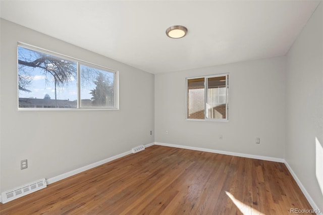 unfurnished room with hardwood / wood-style flooring