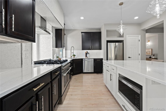 1815 Avery Way, Castle Rock, CO 80109 - kitchen with appliances with stainless steel finishes, light stone countertops, decorative backsplash, dark cabinets, and light wood-style flooring
