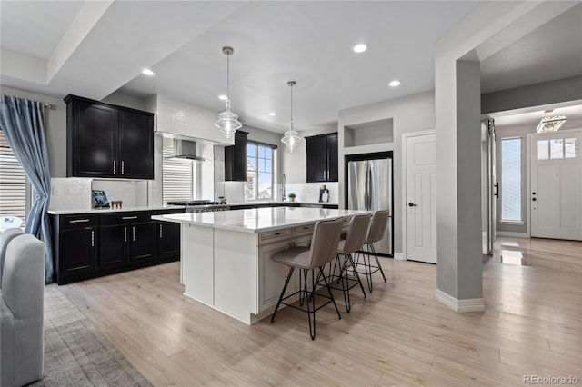 1815 Avery Way, Castle Rock, CO 80109 - kitchen with freestanding refrigerator, dark cabinets, a breakfast bar, a kitchen island, and recessed lighting