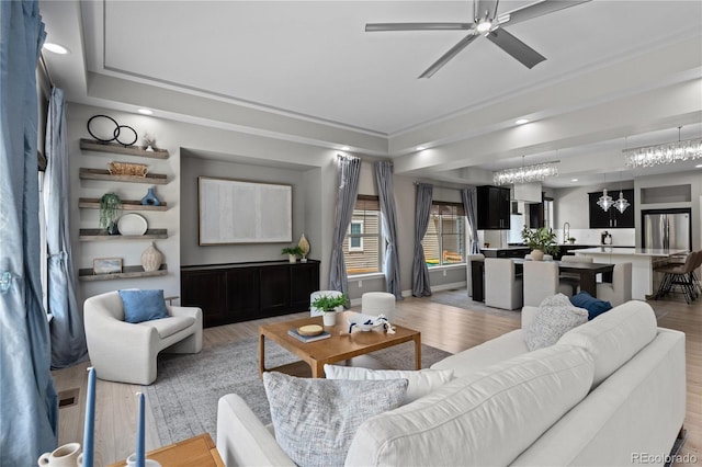 1815 Avery Way, Castle Rock, CO 80109 - living area featuring a chandelier, ceiling fan, light wood-style flooring, a tray ceiling, and recessed lighting