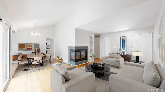 1006 Homestake Dr Unit 1D, Golden, CO 80401 - living area featuring wood finished floors, a chandelier, a multi sided fireplace, lofted ceiling, and recessed lighting