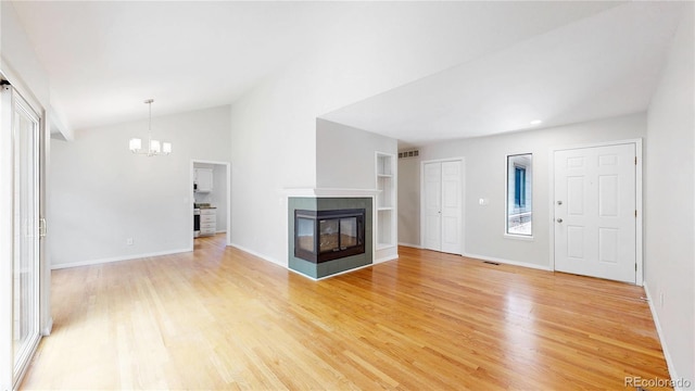1006 Homestake Dr Unit 1D, Golden, CO 80401 - unfurnished living room with a chandelier, a multi sided fireplace, light wood-style floors, and lofted ceiling