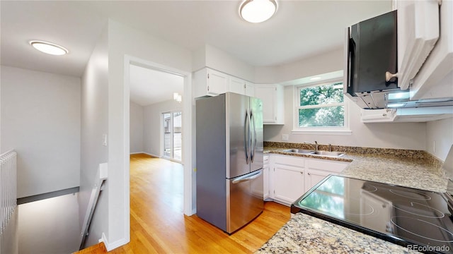 1006 Homestake Dr Unit 1D, Golden, CO 80401 - kitchen with freestanding refrigerator, light wood-style floors, black range with electric cooktop, and white cabinetry