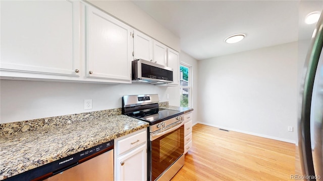 1006 Homestake Dr Unit 1D, Golden, CO 80401 - kitchen with appliances with stainless steel finishes, white cabinetry, light wood-style floors, and light stone countertops
