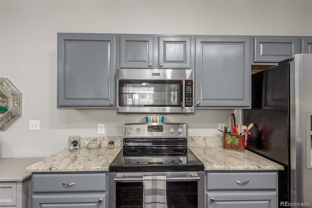 457 Black Feather Loop Unit 702, Castle Rock, CO 80104 - kitchen with appliances with stainless steel finishes, gray cabinetry, and light stone countertops