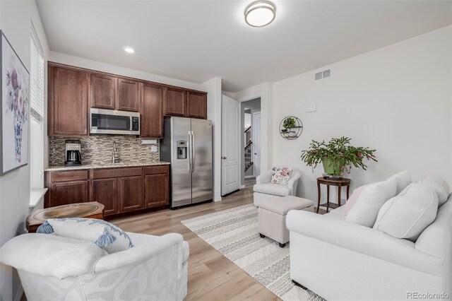 living room featuring light hardwood / wood-style flooring and sink