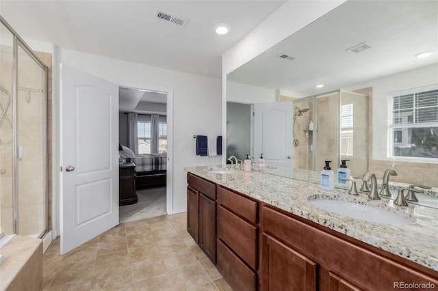 bathroom featuring tile patterned flooring, vanity, and a shower with door