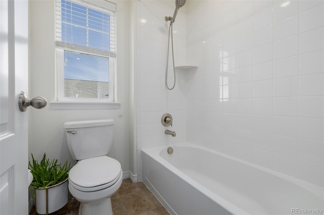 bathroom with tile patterned flooring, tiled shower / bath combo, and toilet