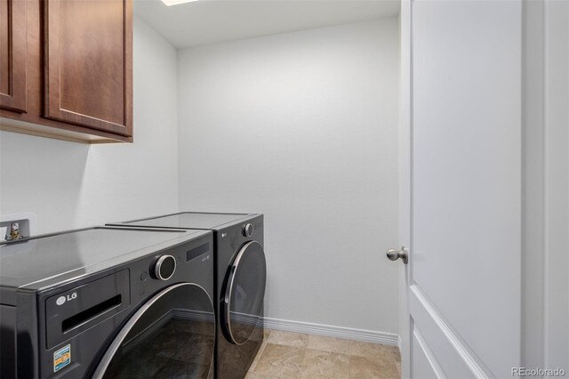 clothes washing area featuring cabinets and washing machine and dryer