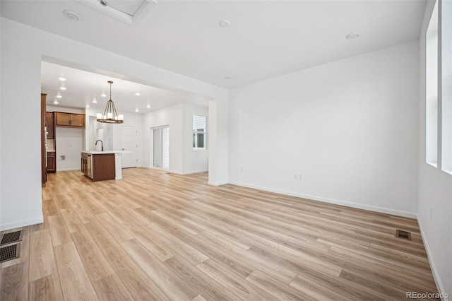 2102 Wagon Wheel Aly, Brighton, CO 80601 - unfurnished living room with light wood-style floors, recessed lighting, and a chandelier