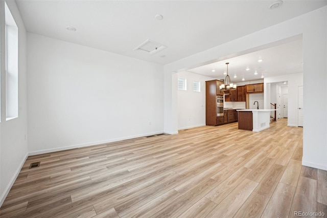 2102 Wagon Wheel Aly, Brighton, CO 80601 - unfurnished living room with light wood-style floors, a chandelier, and recessed lighting