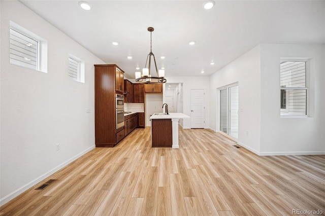 2102 Wagon Wheel Aly, Brighton, CO 80601 - kitchen with light countertops, a chandelier, light wood-type flooring, open floor plan, and recessed lighting
