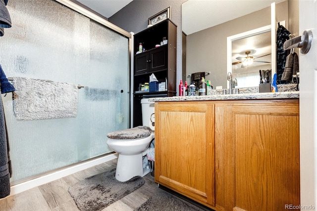 1372 S Cathay Ct Unit 104, Aurora, CO 80017 - bathroom with a stall shower, wood finished floors, toilet, and vanity