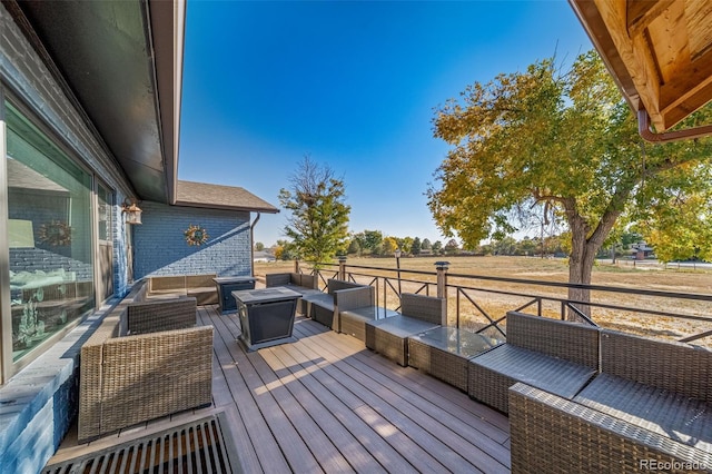 wooden terrace with an outdoor hangout area and a rural view