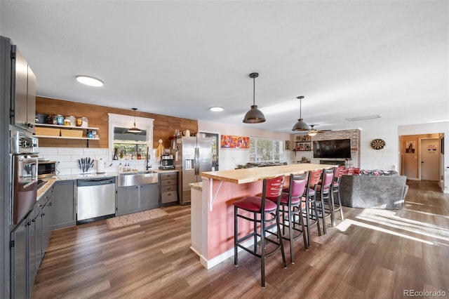 kitchen with butcher block counters, appliances with stainless steel finishes, gray cabinets, and wood finished floors