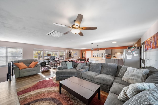 living area with ceiling fan and wood finished floors