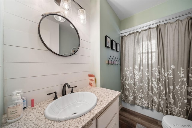 full bathroom featuring toilet, shower / bath combination with curtain, wood finished floors, and vanity