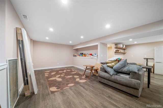 living area with baseboards, wood finished floors, visible vents, and recessed lighting