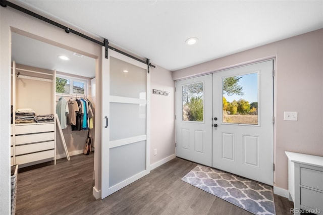 doorway to outside featuring french doors, a barn door, wood finished floors, and baseboards