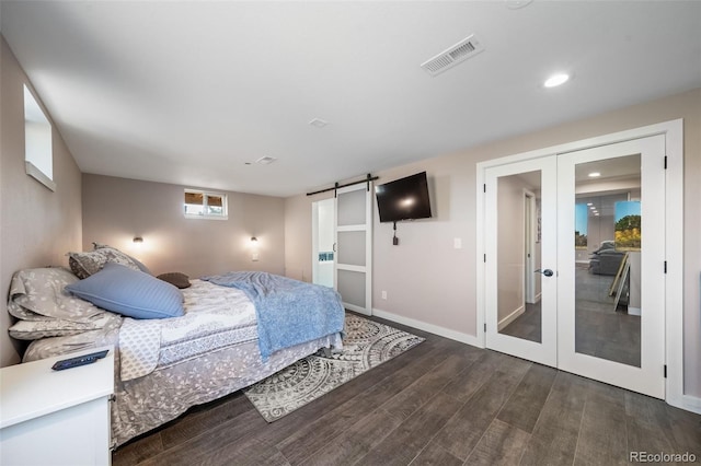 bedroom featuring a barn door, visible vents, wood finished floors, french doors, and recessed lighting