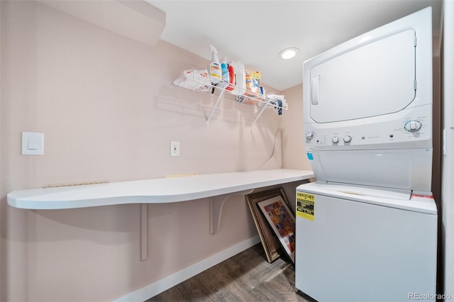 laundry area with recessed lighting, laundry area, stacked washer and dryer, wood finished floors, and baseboards