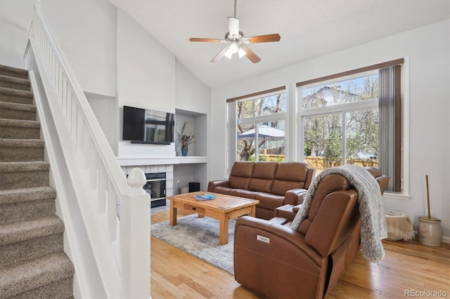 living area with stairway, light wood-type flooring, and a healthy amount of sunlight