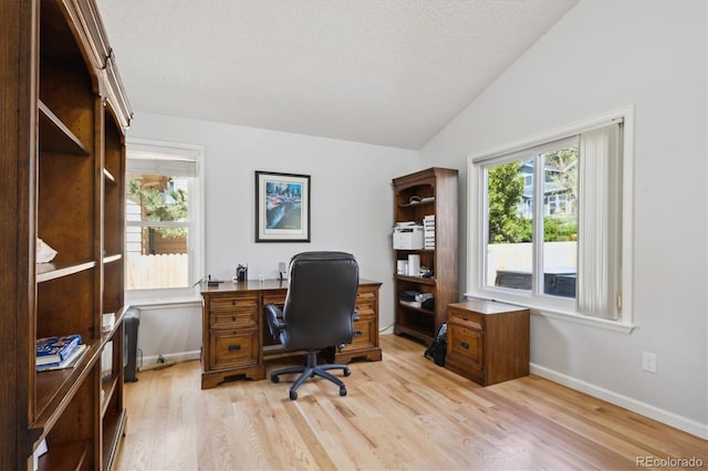 home office featuring baseboards, light wood-style flooring, and vaulted ceiling