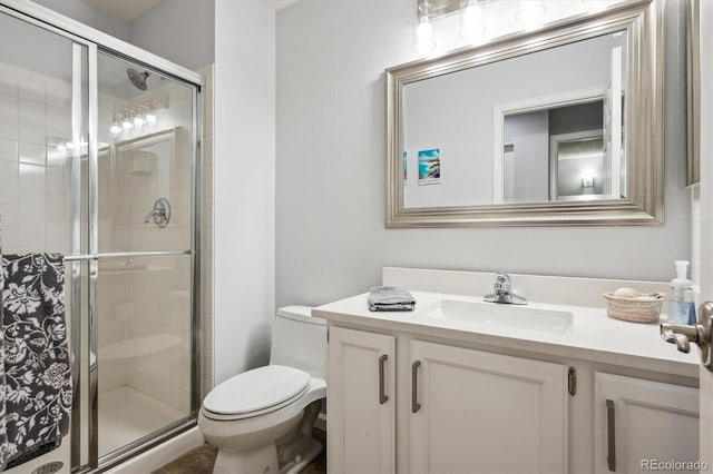 bathroom featuring vanity, toilet, and a stall shower