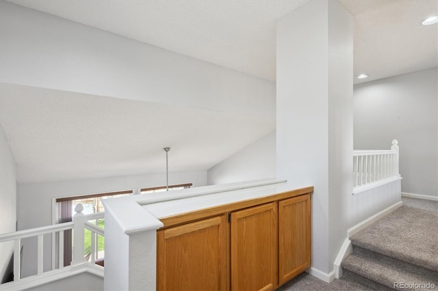 stairway featuring carpet floors, baseboards, vaulted ceiling, and recessed lighting