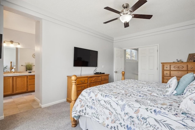 bedroom with light carpet, baseboards, ceiling fan, connected bathroom, and a textured ceiling