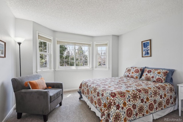 carpeted bedroom with a textured ceiling and baseboards