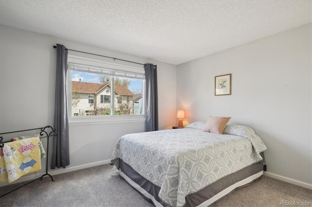 bedroom featuring baseboards, carpet flooring, and a textured ceiling