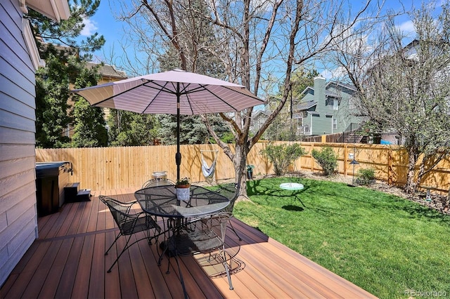 wooden terrace with a lawn, a fenced backyard, and outdoor dining space